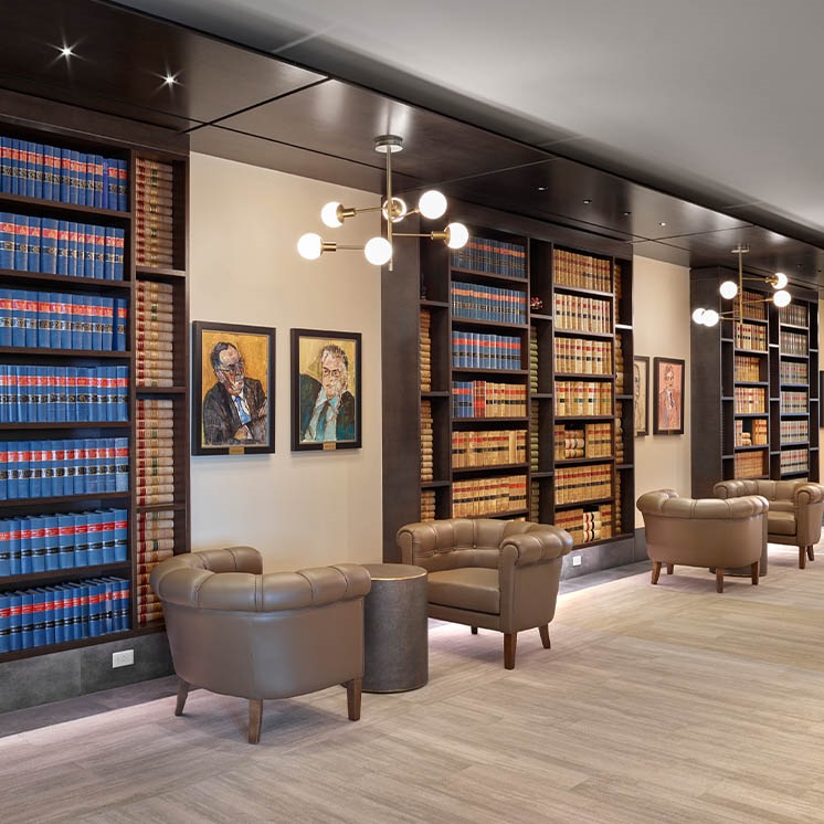 Shared lounge space with comfy leather seats and tall bookshelves